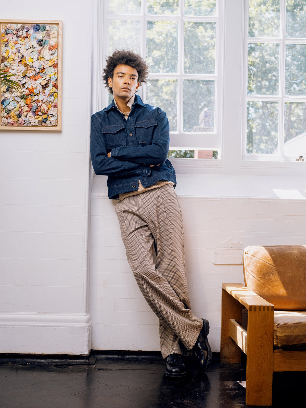 Westall denim Buffalo jacket with houndstooth trousers, leaning against the wall.