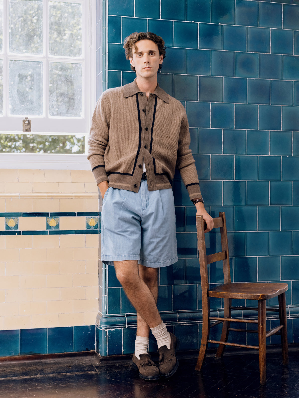Sand knitted cardigan with contrast tipping, worn with indigo pleated shorts.