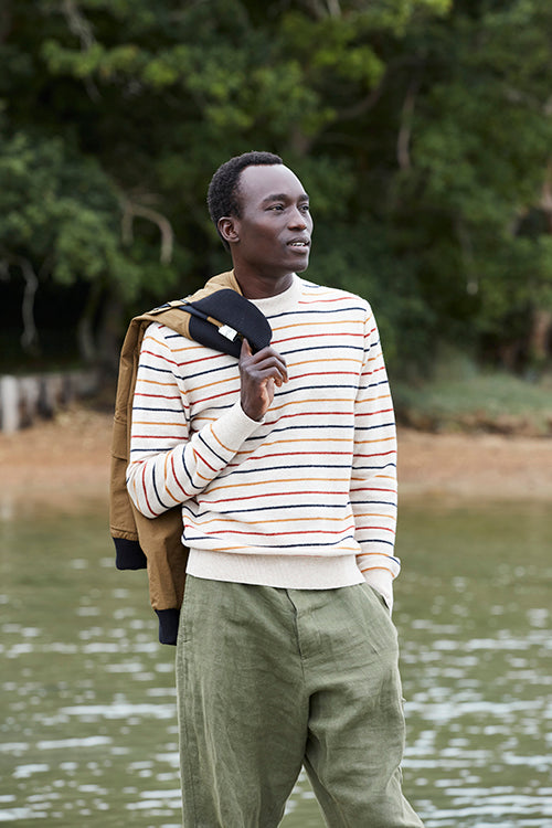 Oliver Spencer Spring 21, look 1. Breton striped knit and olive trousers, photographed by the water.
