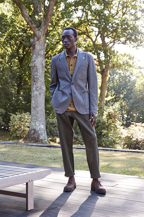 Oliver Spencer Spring 21, look 18. Blue check jacket and grey trousers on garden decking.