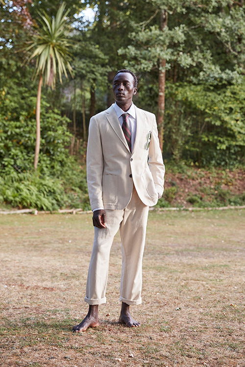 Oliver Spencer Spring 21, look 25. Ivory suit photographed on grass among trees.